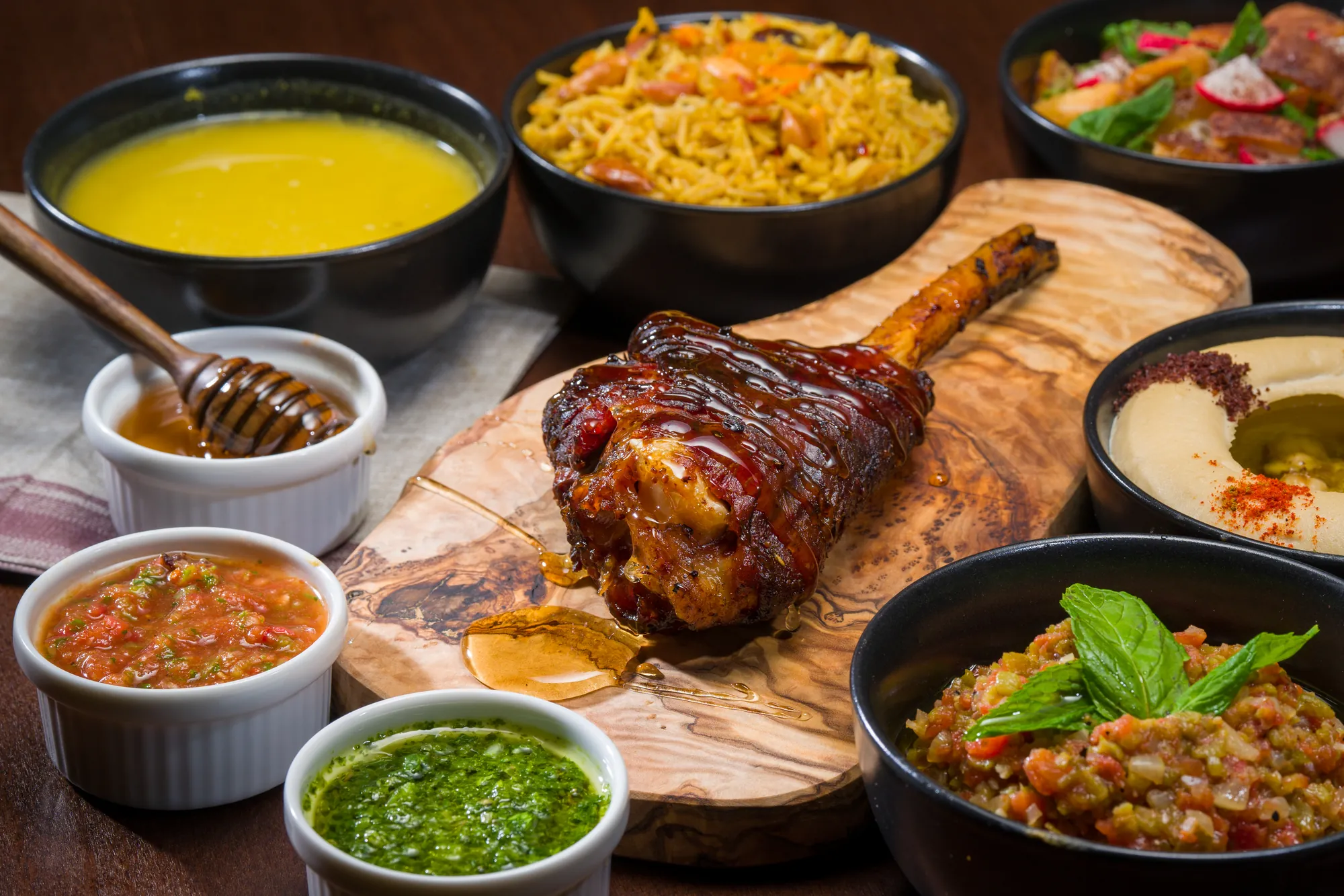Souris d'agneau fumée et ses sauces sur une planche en bois